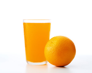 glass of orange juice and orange pieces
