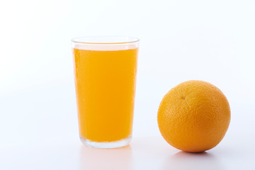 glass of orange juice and orange pieces