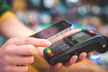Hand of customer paying with contactless by mobile device. Payment with mobile. © Zedspider