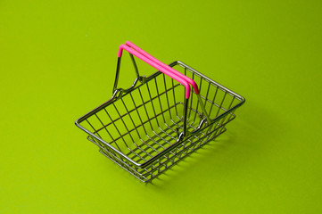 Shopping basket on a green background. Supermarket food price concept, holiday discounts