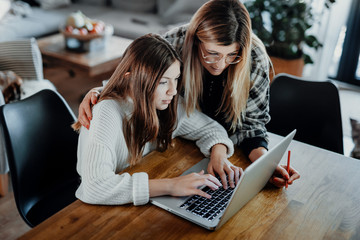 Mother and child doing homeschooling, e-learning at home because of the corona virus pandemic...