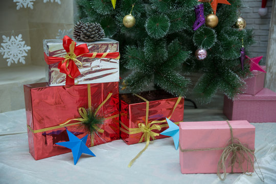 present boxes at christmas tree. happy new year. celebrate xmas at home. winter holiday shopping. shopping sales. gift delivery. Red, pink, silver gift boxes tree background.Christmas online shopping.