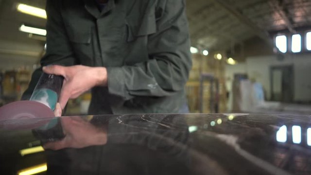  Worker in a green jacket polishes a marble table in a factory. Super Slow Motion