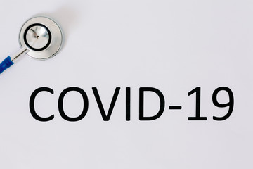  Doctor's stethoscope on a white background with the inscription "covid-19"