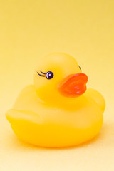 Rubber duck on a yellow background minimally creative concept. bathing babies. vertical photo