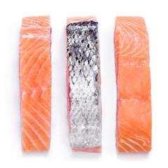 Raw salmon fillets, isolated on white background. Fresh fish, sushi quality salmon. Top view or high angle shot.