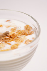 Half a glass with a healthy breakfast - Greek yogurt with granola and honey, on a white background