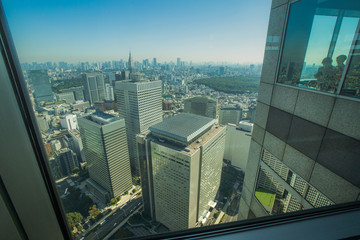 Fototapeta na wymiar Tokyo Skyline Looking through the glass from tall buildings, see the office building in the central business district.