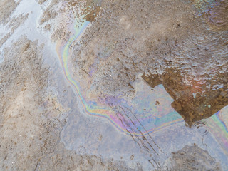 Spill of petrol in the road puddle. Gasoline footprint rainbow on the asphalt. Concept of...