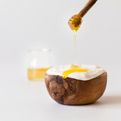 Greek yogurt with honey and granola in a wooden bowl.Concept Healthy breakfast.