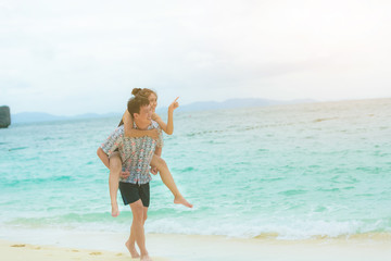 Fototapeta premium Happy young asian couple having fun at beach on sunny day.
