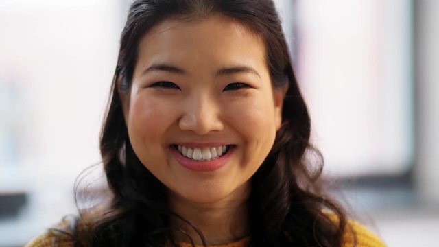 people, ethnicity and race concept - portrait of happy smiling asian young woman at home