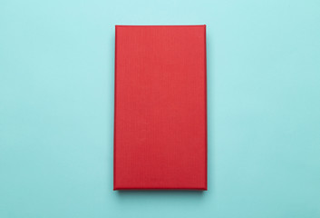 Red box product packaging isolated on blue background. Flat lay Top view.