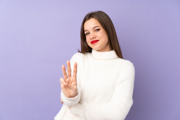 Teenager girl isolated on purple background happy and counting three with fingers