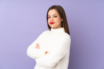 Teenager girl isolated on purple background with arms crossed and looking forward
