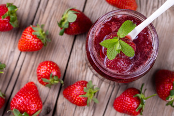 Homemade delicious strawberry jam and strawberry on a rustic wooden table