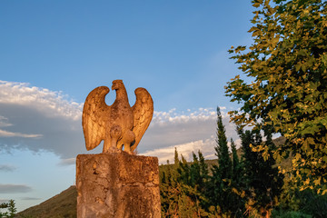 Stone eagle statue with blue sky in a countryside at the sunset