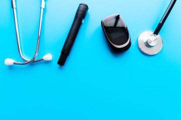 Medicine, Diabetes, Glycemia, Health care and people concept - close up of lancelet, Glucose meter and stethoscope on gray background.
