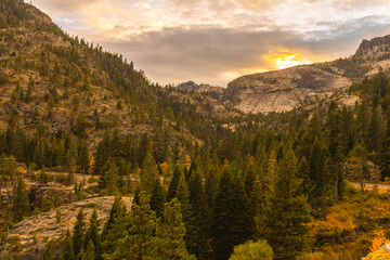 Detail of the sunset sky over the rocky mountain and the pines next to Emerald Bay in Lake Tahoe