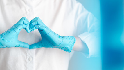 hands gesture of doctor wearing blue gloves, heart shape sign for love