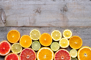 Various types of citrus fruits cut into slices on the old wooden board