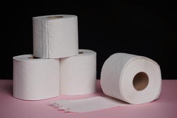 Soft hygienic toilet paper on black pink background.