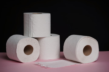 Soft hygienic toilet paper on black pink background.