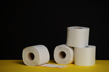 Many toilet paper rolls. Soft hygienic paper. Black yellow background.