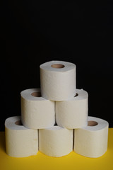 Many toilet paper rolls. Soft hygienic paper. Black yellow background.