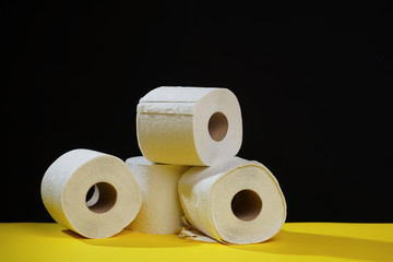 Many toilet paper rolls. Soft hygienic paper. Black yellow background.