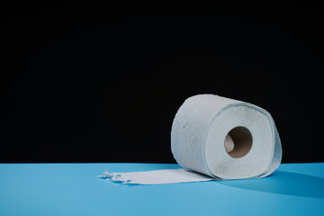 Toilet paper roll. Soft hygienic paper. Black blue background.