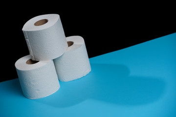 Toilet paper roll. Soft hygienic paper. Black blue background.