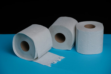 Toilet paper roll on a black blue background. Cheap toilet wipes for hygiene purposes. Soft hygienic paper.