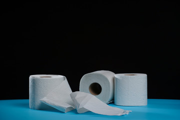 Toilet paper roll. Soft hygienic paper. Black blue background.