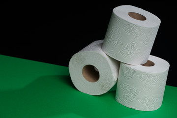 Toilet paper roll. Soft hygienic paper. Black green background.