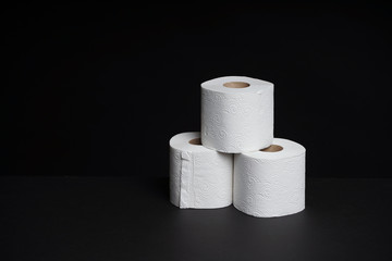 Toilet paper rolls on a black background. Cheap toilet wipes for hygiene purposes.