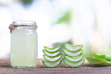 Fresh aloe vera stem slices and gel on wooden table, skin therapy concept