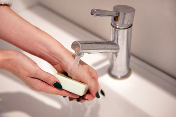 hand washing with soap at home bath. Washing of hands with soap under the crane with water