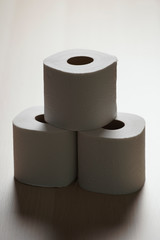 Many toilet paper rolls in a pile. Soft hygienic paper. Wooden table on black background.