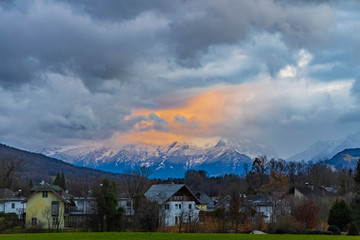 twilight depressive Europe village landmark park outdoor scenic view with Alps mountain background and beautiful dramatic cloudy sky and evening sunset lighting