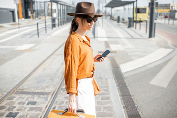 Obraz premium Young female traveler walking with a luggage on the city street. Arriving to the city while travel
