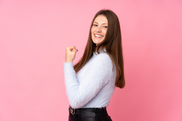 Teenager caucasian girl isolated on pink background celebrating a victory