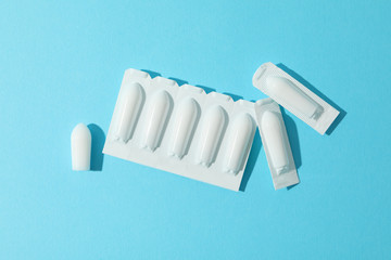 Anal or vaginal candles on blue background, top view