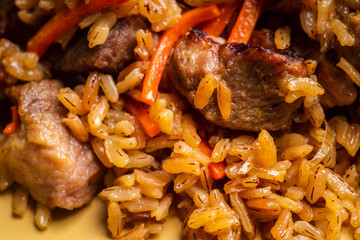 Traditional Uzbekistan pilaf on the rustic background. Selective focus. Shallow depth of field.