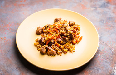 Traditional Uzbekistan pilaf on the rustic background. Selective focus. Shallow depth of field.