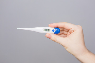Thermometer in the hands of a girl, the epidemic of coronavirus in the world