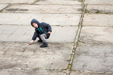 A little boy is playing on concrete blocks.