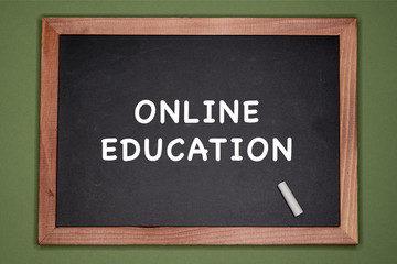 Fototapeta premium Online education written on chalkboard, green background