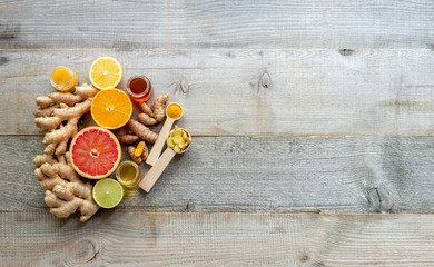 Top view on the immune system booster - ginger, turmeric, citruses, and honey on the old wooden board