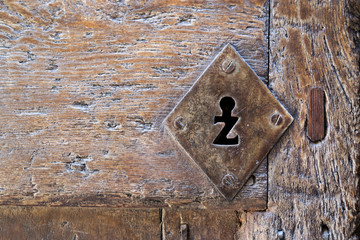 Old wooden door with a hole in the strange and peculiar shape key.